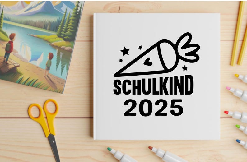 May include: A white notebook with the words "SCHULKIND 2025" and a black graphic of a school cone with stars. The image also includes a colorful landscape painting, yellow scissors, and markers on a wooden surface.