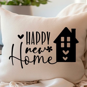 May include: White cushion with black text that reads "Happy new home" and a black silhouette of a house with hearts.