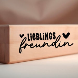 Puede incluir: Un bloque de madera con el texto "LIEBLINGS freundin" y dos peque&ntilde;os corazones a cada lado del texto.
