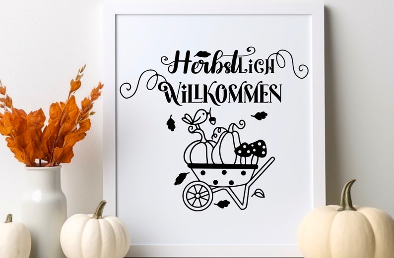 May include: Black and white illustration of a wheelbarrow filled with pumpkins and mushrooms. The text "Herbstlich Willkommen" is written in a decorative font above the wheelbarrow.