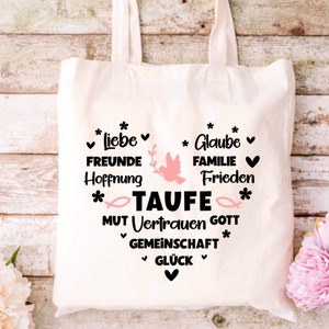 May include: White canvas tote bag with black text that reads "*Liebe* FREUNDE Hoffnung *Glaube* FAMILIE Frieden *TAUFE* MUT Vertrauen GOTT GEMEINSCHAFT *GL&Uuml;CK*" with a pink dove and fish graphic.