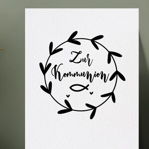 Peut inclure: Une illustration en noir et blanc d'une couronne de feuilles et de c&oelig;urs entourant le texte "Zur Kommunion" et un petit symbole de poisson.