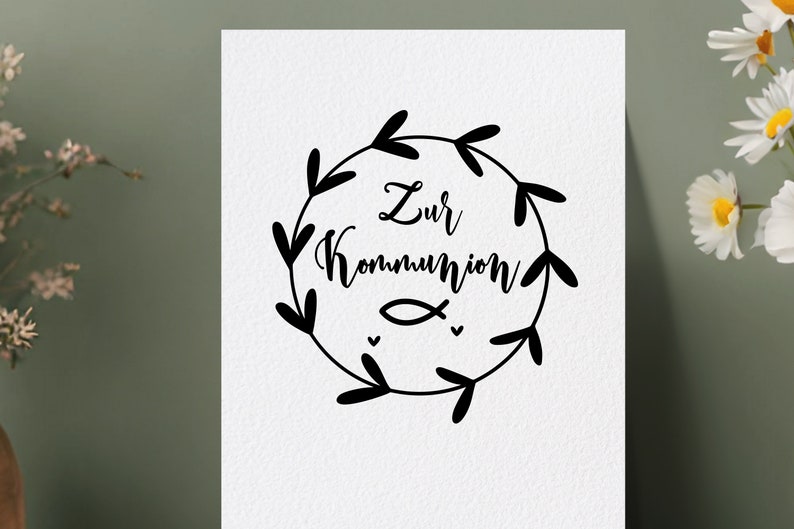 Peut inclure: Une illustration en noir et blanc d'une couronne de feuilles et de c&oelig;urs entourant le texte "Zur Kommunion" et un petit symbole de poisson.