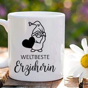 K&ouml;nnte beinhalten: Wei&szlig;e Keramiktasse mit einer schwarz-wei&szlig;en Illustration eines Zwergs, der ein Herz h&auml;lt. Der Text "WELTBESTE ERZIEHERIN" ist auf die Tasse gedruckt.