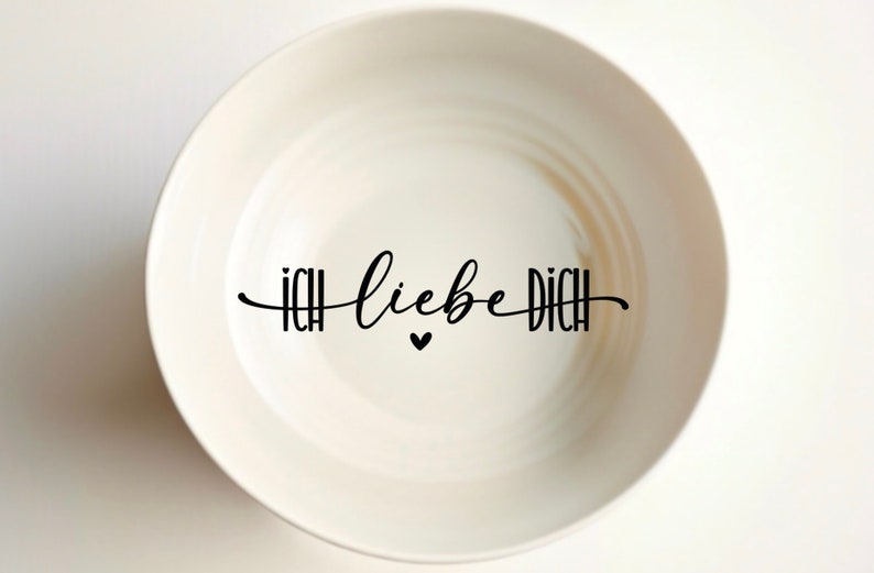Puede incluir: Taz&oacute;n de cer&aacute;mica blanco con el texto "ICH liebe DICH" y un peque&ntilde;o coraz&oacute;n en letras negras.