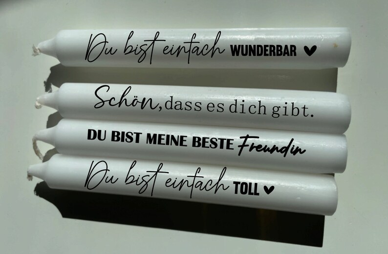 Puede incluir: Cuatro velas blancas con texto negro. El texto en las velas dice: "Du bist einfach WUNDERBAR", "Sch&ouml;n, dass es dich gibt.", "DU BIST MEINE BESTE Freundin" y "Du bist einfach TOLL".