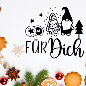 May include: Black and white illustration of a gnome holding a Christmas tree with the text "F&Uuml;R DICH" on a white background with Christmas decorations.