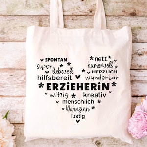 K&ouml;nnte beinhalten: Eine wei&szlig;e Stofftasche mit schwarzem Text, der "SPONTAN, super liebevoll, hilfsbereit, *ERZIEHERIN*, witzig, kreativ, menschlich, Wahnsinn, lustig" und "*nett*, humorvoll, *HERZLICH, wunderbar" lautet.