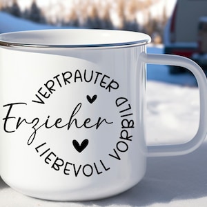 K&ouml;nnte beinhalten: Wei&szlig;e Emaille-Tasse mit einem schwarzen Kreisdesign, auf dem "Vertrauter Erzieher Liebevoll Vorbild" mit zwei schwarzen Herzen steht.