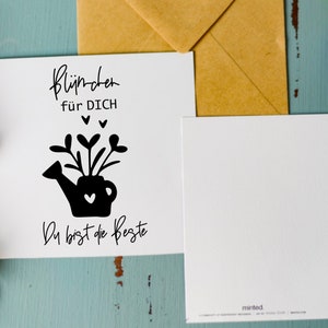 May include: A white card with black text and a black silhouette of a watering can with flowers and hearts. The text reads "Bl&uuml;mchen f&uuml;r DICH" and "Du bist die Beste".