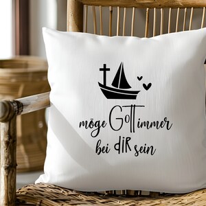 May include: White throw pillow with black text that reads "m&ouml;ge Gott immer bei dir sein" and a black silhouette of a sailboat with a cross on the mast and two hearts.