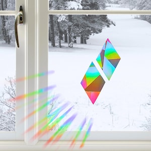 Puede incluir: Dos pegatinas geométricas para ventana en forma de diamante con un acabado holográfico que refleja la luz en un espectro de colores. Las pegatinas están aplicadas sobre un cristal, proyectando un patrón de refracción de luz vibrante y colorido.