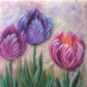 May include: Three purple and pink tulips with green leaves on a light pink background. The tulips are made of wool felt and have a soft, fuzzy texture.