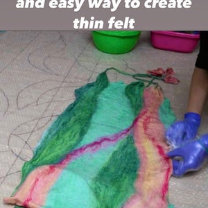 May include: A close-up of a colorful, thin felt fabric being felted by hand. The fabric is green, pink, and yellow. The fabric is being felted on a white surface with a black grid pattern. The text "Svetlana Tymofeyeva" is visible in the bottom right corner of the image.