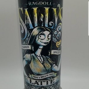 May include: A black and white tumbler with a graphic of Sally from The Nightmare Before Christmas. The text on the tumbler reads "Ragdoll Sally's Pumpkin Spiced Frog's Breath Free Latte".
