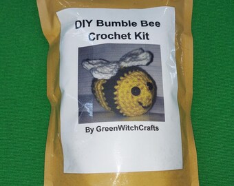 Peut inclure: Un sac en papier brun avec une étiquette blanche qui dit "DIY Bumble Bee Crochet Kit" et présente une abeille en crochet avec des rayures jaunes et noires, des ailes blanches et des yeux noirs. L'étiquette indique également "By GreenWitchCrafts".