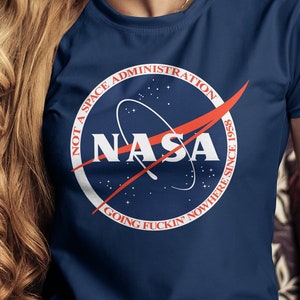 May include: A navy blue t-shirt with a white circle graphic featuring the NASA logo and the text "Not a Space Administration. Going Fuckin Nowhere Since 1958."