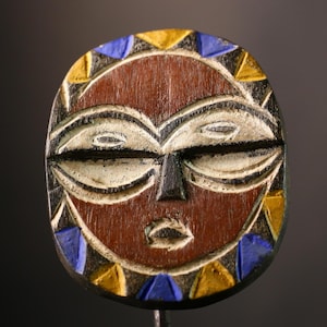 African wood mask Bwa sun mask wall art with tribal geometric design in red yellow blue tones handmade rustic cultural face decor G3608