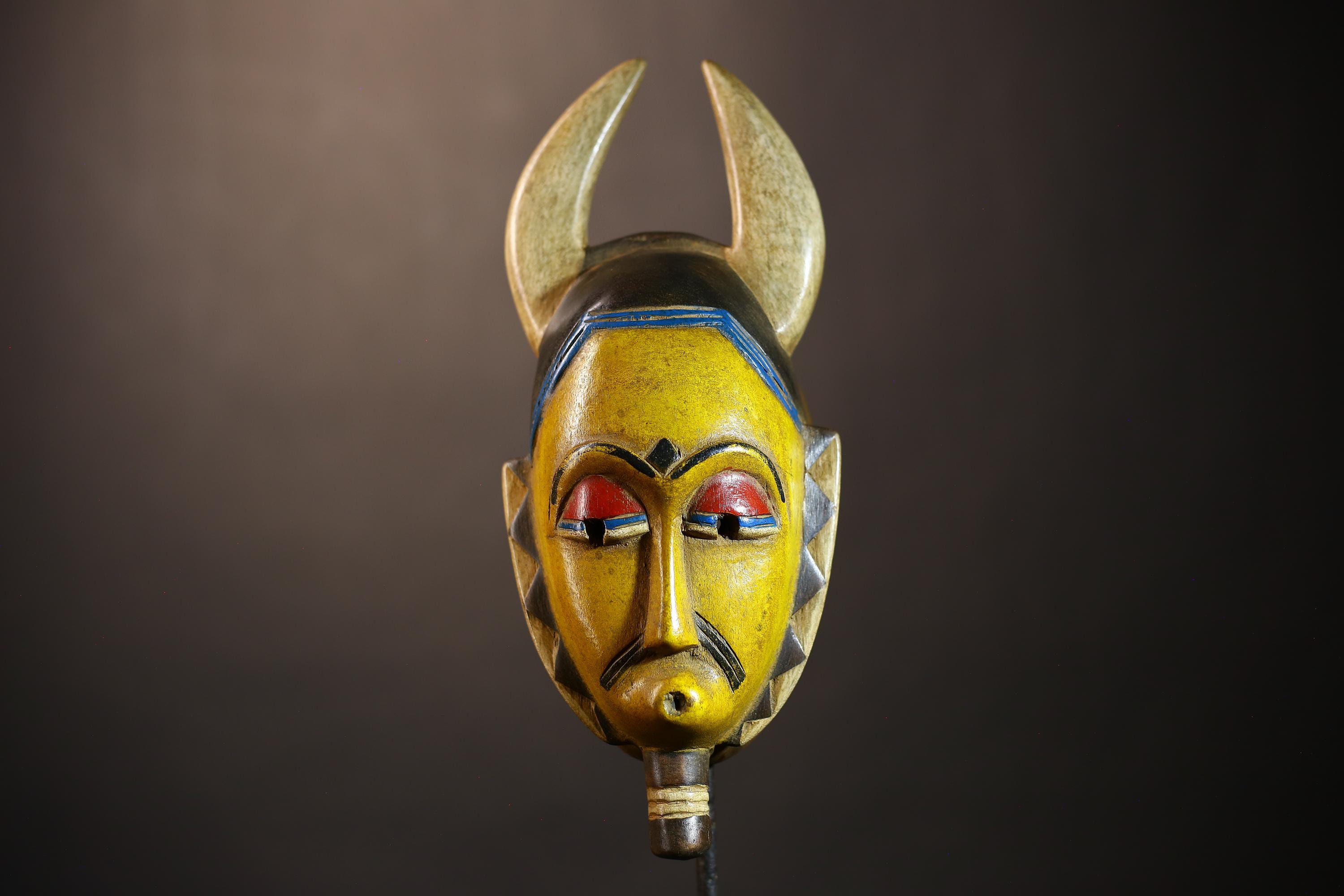 アフリカのグロマスク：手彫りの角のある木製の彫刻、部族の壁アート