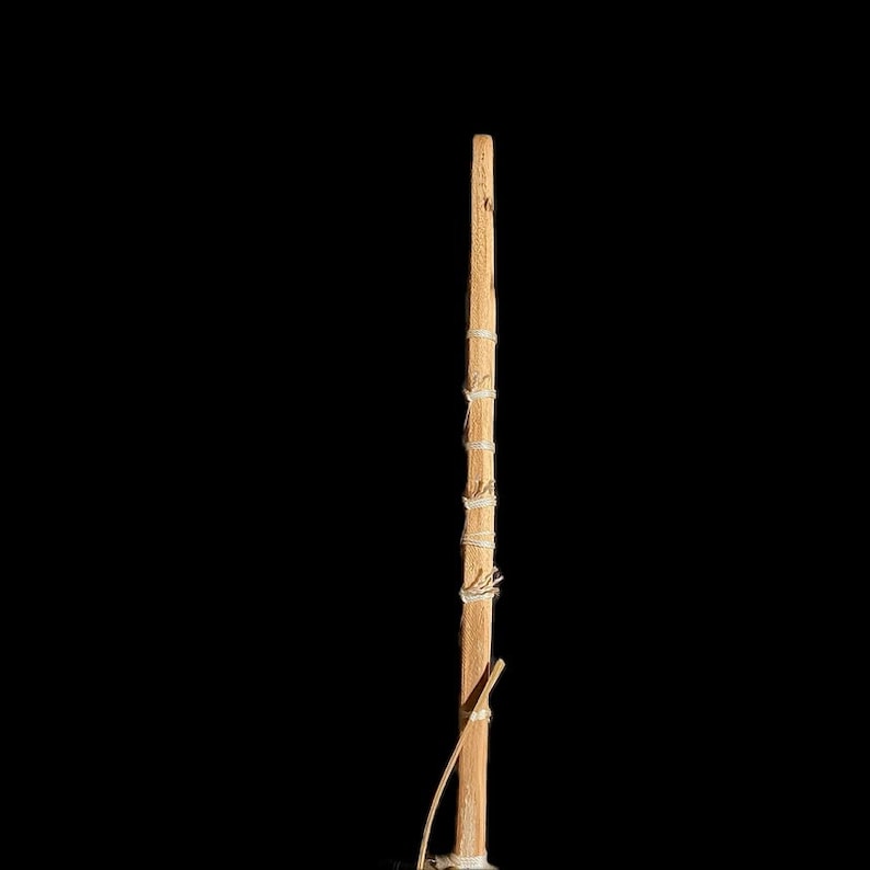 May include: A wooden stick with white string wrapped around it. The stick is about 18 inches long.