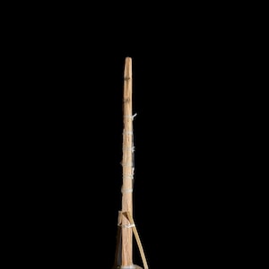 May include: A wooden stick with string wrapped around it. The stick is brown and the string is white.