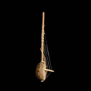 May include: A wooden kora, a traditional West African harp, with a round, leather-covered soundboard and multiple strings.