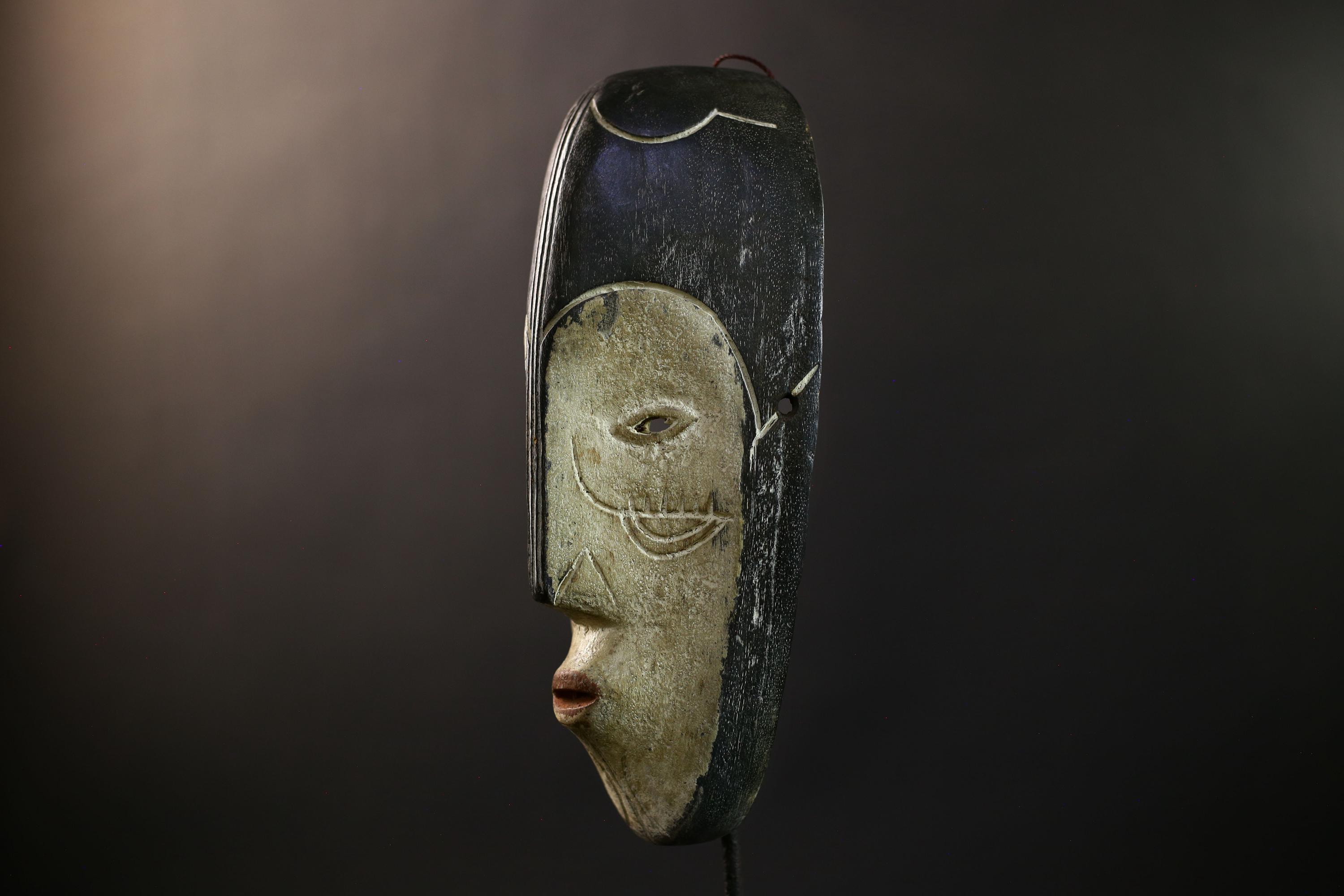 アフリカの牙のンギルマスク：ガボンの部族芸術、手彫りのオクメ材