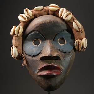 Máscara tribal africana: borde de concha de cauri, arte mural de madera tallada - 9912