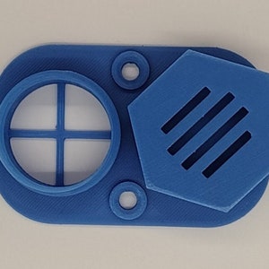 May include: A blue plastic air filter with a hexagonal cover. The filter has a circular opening with a cross-shaped grid. The cover has five vertical slits.