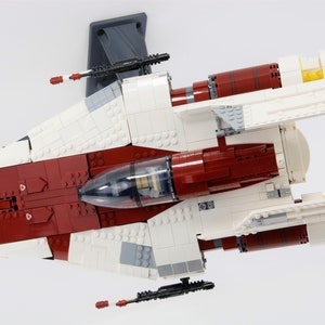 May include: A white and red Lego Star Wars V-4X-D starfighter with a clear cockpit and yellow engine exhausts.