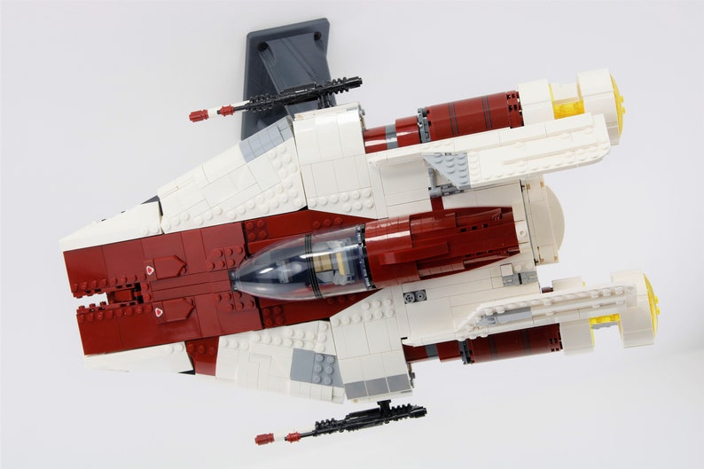 May include: A white and red Lego Star Wars V-4X-D starfighter with a clear cockpit and yellow engine exhausts.