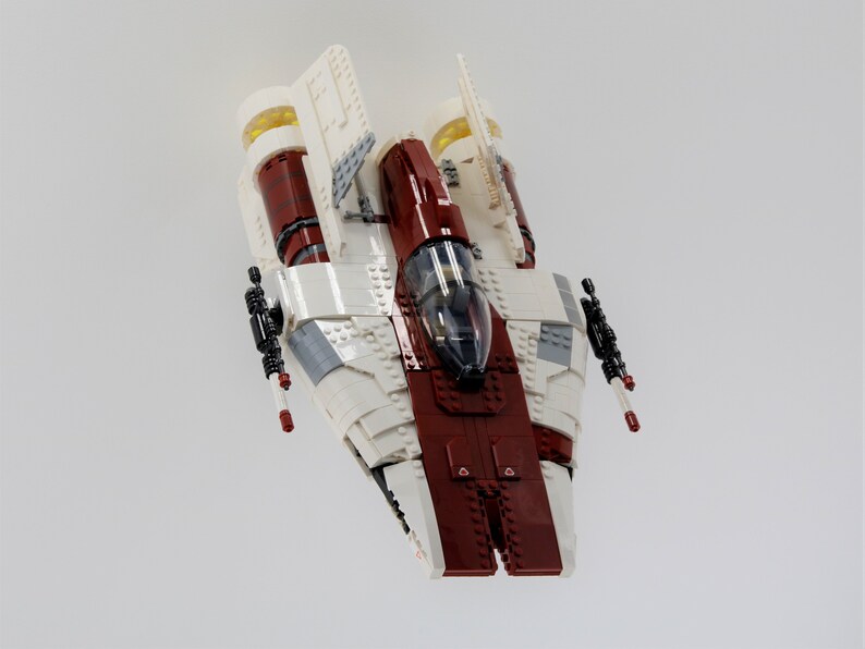 May include: A white and red Lego spaceship with black details and clear cockpit windows.