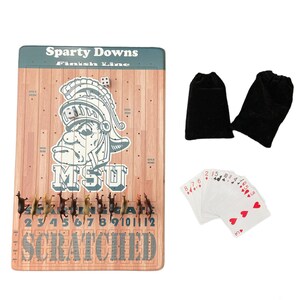 May include: A wooden game board with a green and brown finish. The board features a horse racing theme with a Spartan helmet logo and the text "Sparty Downs Finish Line". The board includes a set of horses, dice, and playing cards.