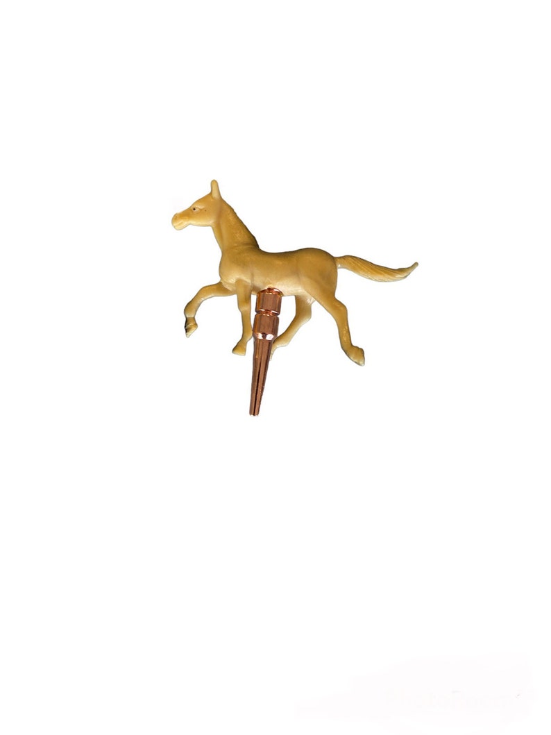 May include: A small, brown plastic horse figurine with a gold-colored metal base. The horse is in a running pose with its head turned to the side.