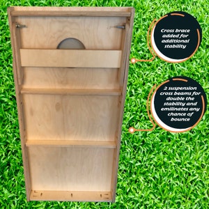 May include: A wooden cornhole game board with a back panel that has three shelves and a cross brace for stability. The text "Cross brace added for additional stability" and "2 suspension cross beams for double the stability and eliminates any chance of bounce" is written on the image.