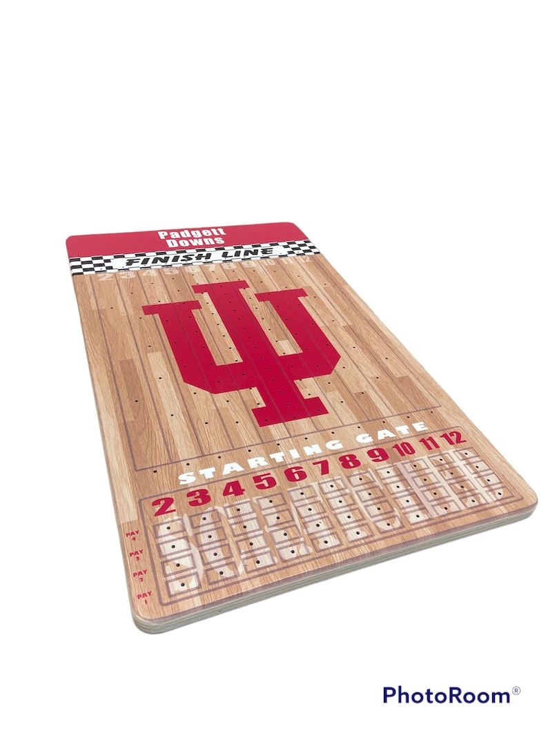 May include: A wooden game board with a red Indiana University logo and a basketball court design. The board has a starting gate with numbers 2 through 12 and a finish line. The game is called "Padgett Downs".