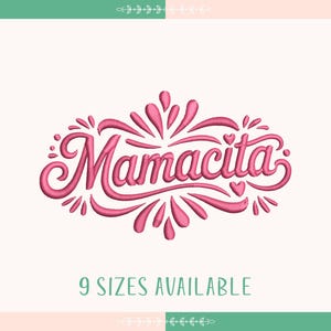 Può includere: Un disegno ricamato rosa con la scritta "Mamacita" in corsivo, circondato da decorazioni. Il testo "9 taglie disponibili" è sotto il disegno. Lo sfondo è color crema chiaro con un bordo verde e rosa.