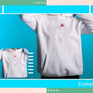 May include: White hoodie with a small pink butterfly and heart design embroidered on the front. The hoodie has a kangaroo pocket and a drawstring hood.