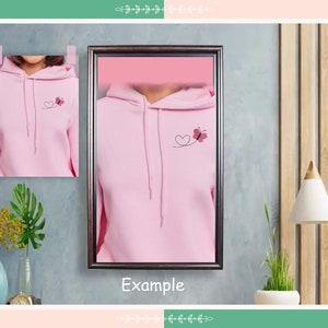 May include: Pink hoodie with a small heart and butterfly design on the front. The hoodie has a drawstring hood and a kangaroo pocket.