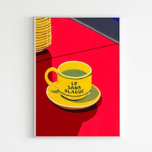 May include: A yellow coffee cup with a green saucer sits on a red surface. The cup has the text "LE SANS BLAGUE" printed on it.