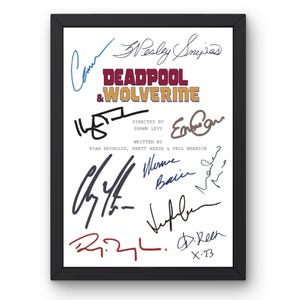 Op de afbeelding: Zwart ingelijste print met de titel "DEADPOOL & WOLVERINE" in bordeauxrood en goud, omringd door meerdere handtekeningen in verschillende kleuren. De print bevat ook de namen van de regisseur en schrijvers.