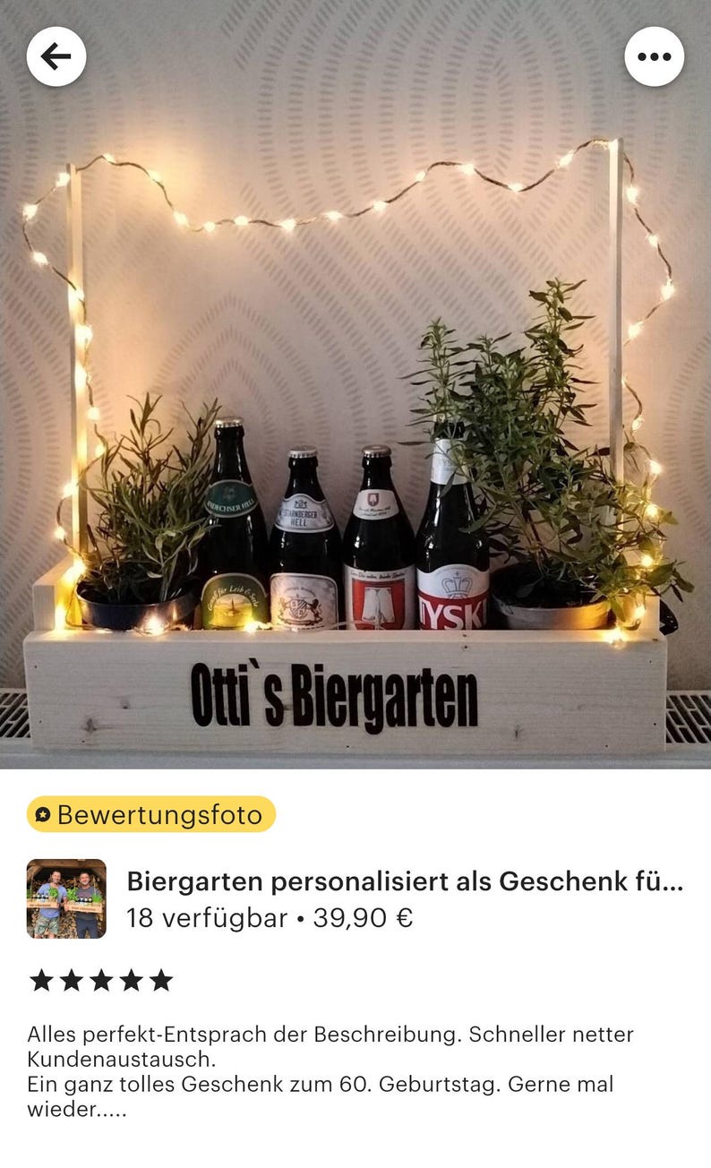 May include: A wooden crate with a sign that reads "Otti's Biergarten" and is decorated with string lights and potted plants. There are six bottles of beer in the crate.