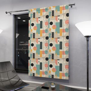 May include: A patterned curtain with a geometric design in pastel colors of peach, teal, yellow, and black. The curtain hangs in front of a window, adding a pop of color to the room. The design includes circles, rectangles, and lines.