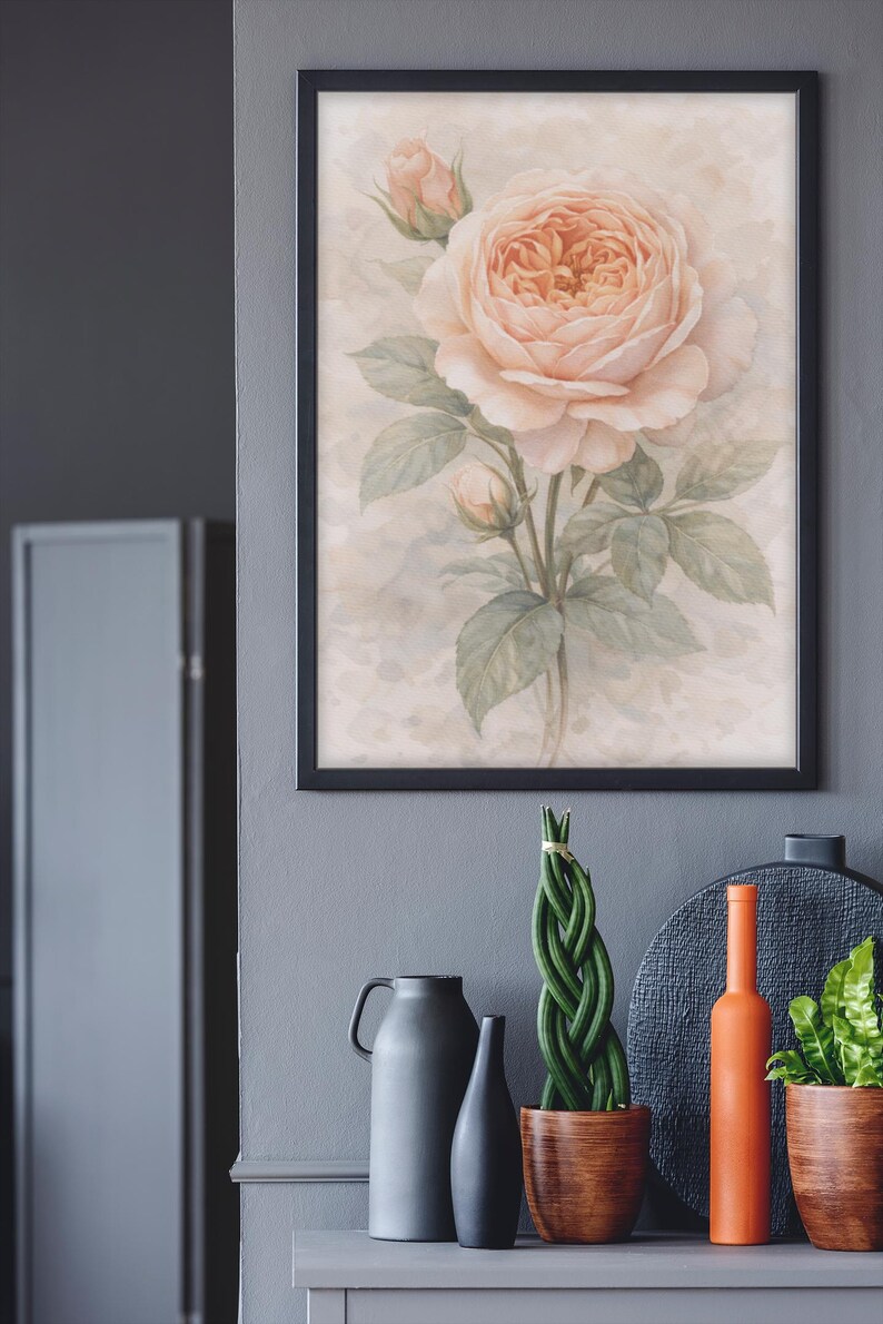 Pu&ograve; includere: Una stampa artistica da parete incorniciata raffigurante un'illustrazione ad acquerello di una grande rosa color pesca pallido in piena fioritura, accompagnata da due boccioli e foglie verdi su uno sfondo neutro e maculato.