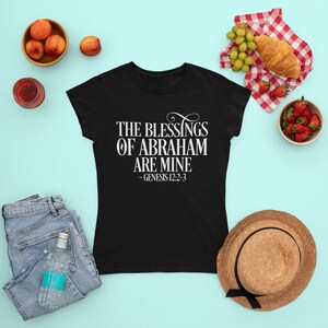 Puede incluir: Camiseta negra con texto blanco que dice "The Blessings of Abraham Are Mine - Genesis 12:2-3".