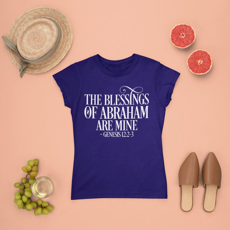 Puede incluir: Una camiseta azul real con texto blanco que dice "The Blessings of Abraham are Mine - Genesis 12:2-3".