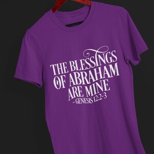 Puede incluir: Camiseta morada con texto blanco que dice "The Blessings of Abraham are Mine - Genesis 12:2-3"