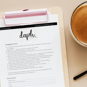 May include: A consignment agreement form with the title "Consignment Agreement (1 of 25)" and the company name "daph." printed on a white sheet of paper on a wooden clipboard.