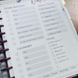 May include: A weekly planner page with a light gray background and a white grid. The page is divided into sections for "Home Blessing", "Laundry", "Daily Theme", and "Other". Each section has a list of tasks or activities to be completed. The page also includes checkboxes for each task.