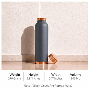 Puede incluir: Una botella de agua cilíndrica de color gris oscuro mate con tapa y base de color cobre metálico. La botella tiene una altura de 24,89 cm, un ancho de 6,86 cm, un peso de 270 gramos y una capacidad de volumen de 900 mililitros.